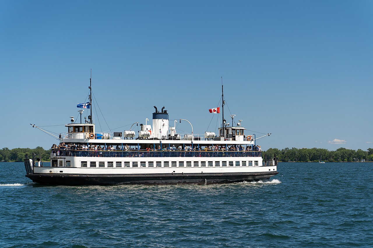 A Toronto island ferry on the harbour, with the city behind it