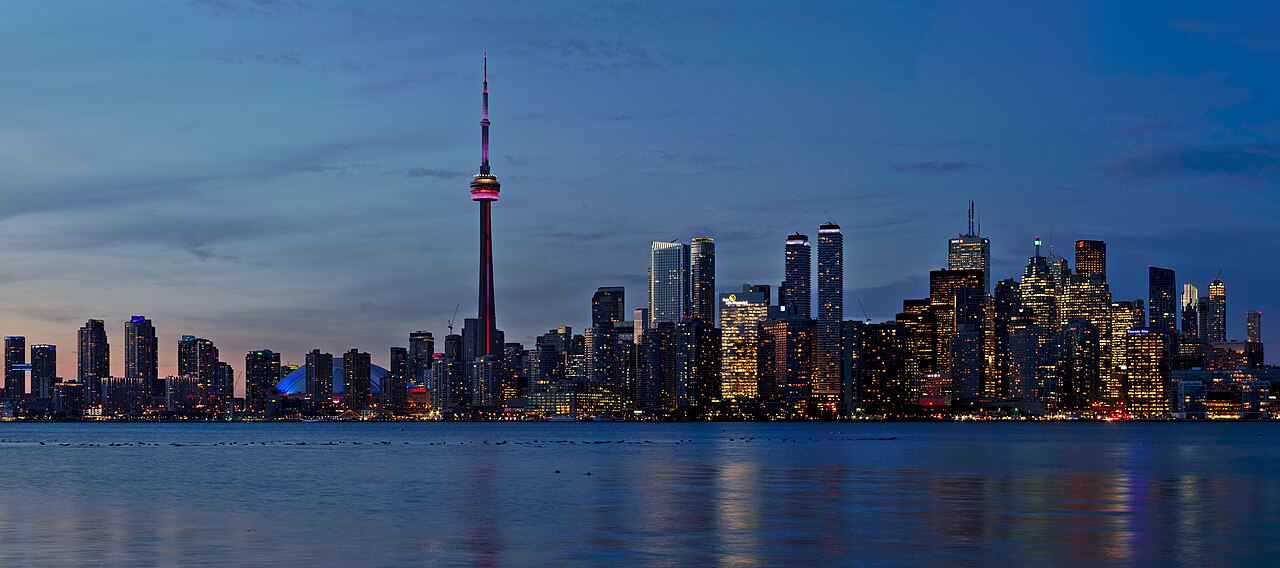 Toronto skyline at sunset, seen across the water, with the tower in the middle distance